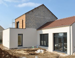 Photo chantier maison avec bardage bois et enduit